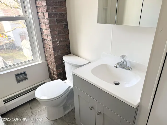 a white toilet sitting next to a bath tub