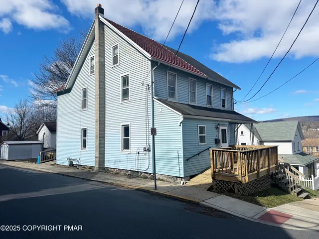 a view of a house with wooden deck area