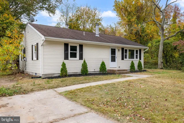 a view of a yard in front of a house with large tree