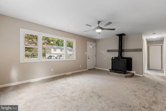 a view of room with ceiling fan and windows