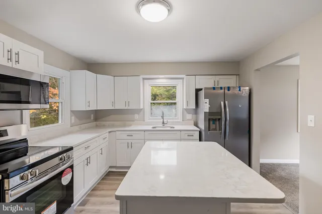 a kitchen with refrigerator cabinets and wooden floor