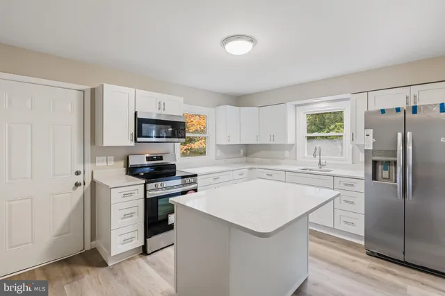 a kitchen with cabinets stainless steel appliances and a window