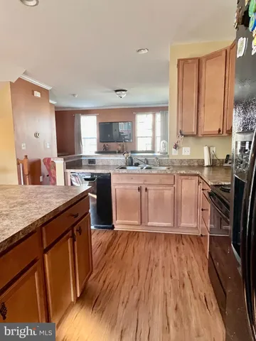 a kitchen with wooden floors appliances and sink