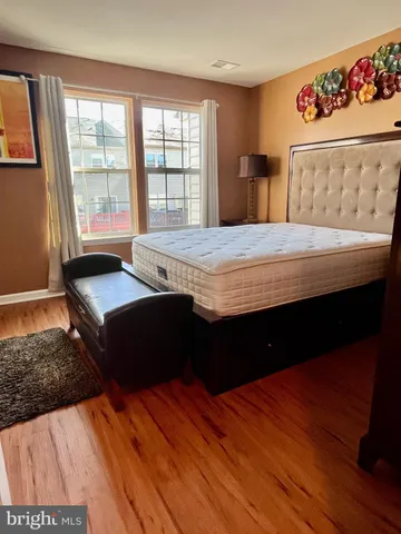 a bedroom with a bed and wooden floor