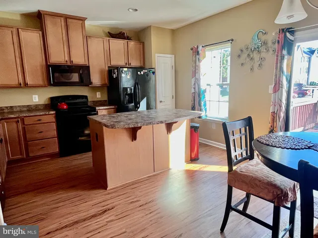 a kitchen with stainless steel appliances granite countertop a table chairs microwave and sink