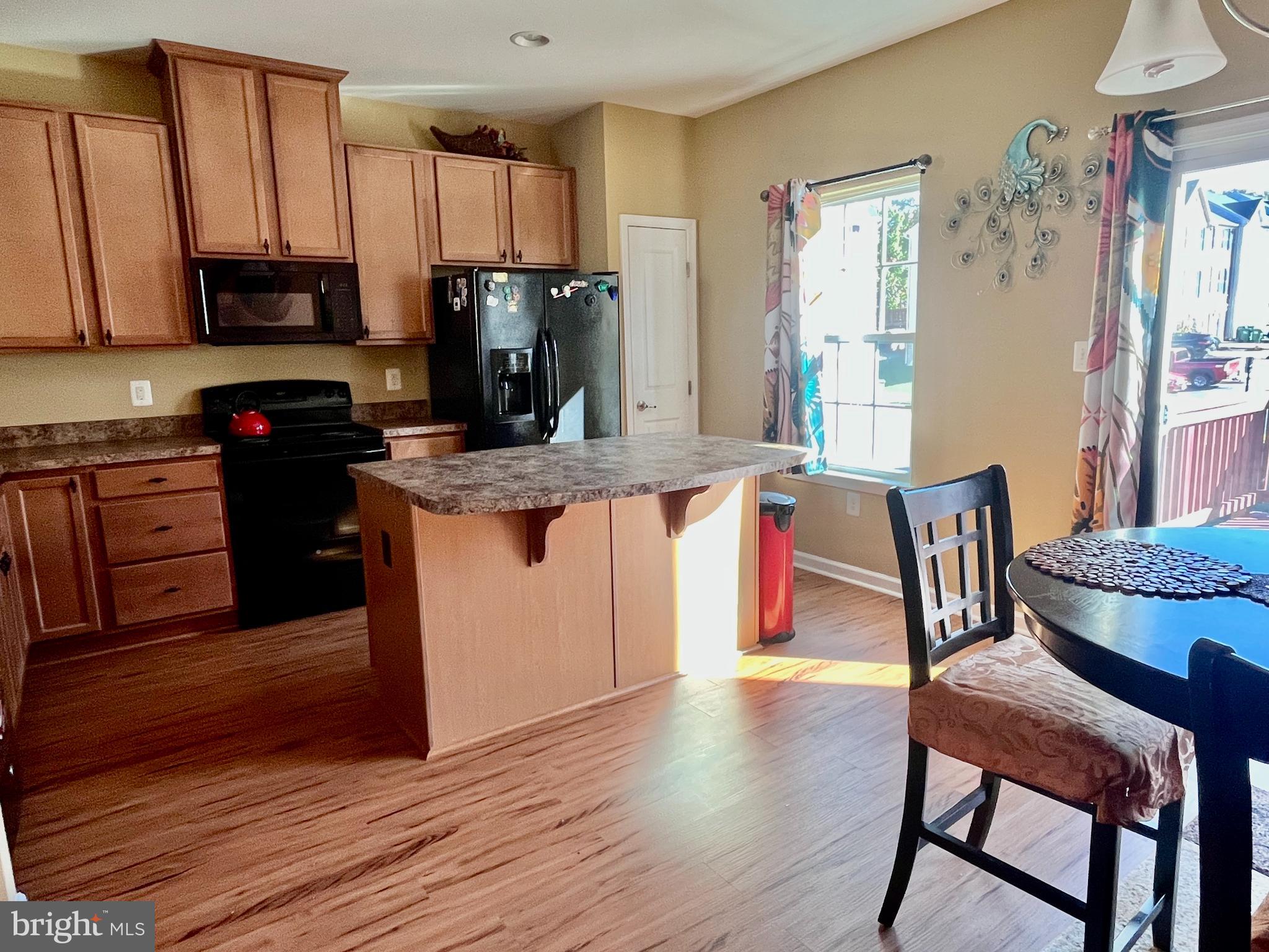 312 Spring Park Lane, Unit 59 Fredericksburg, VA 22405 - Photo 9 of 20 a kitchen with stainless steel appliances granite countertop a table chairs microwave and sink