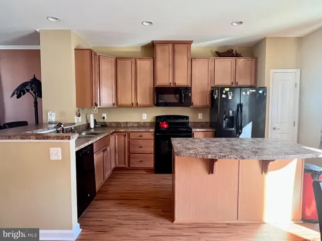 a kitchen with stainless steel appliances granite countertop a stove a sink dishwasher and a refrigerator