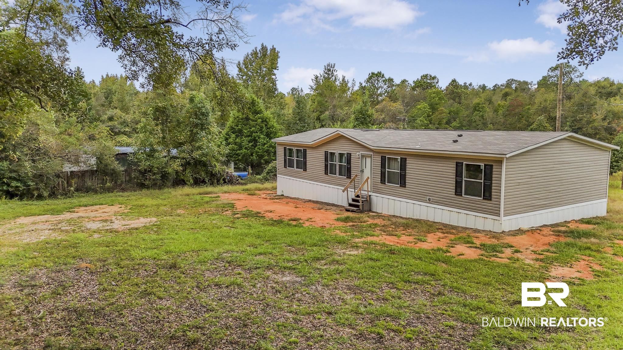 54309 Klasnich Road Perdido, AL 36562 - Photo 2 of 29 Rear view of house with a yard