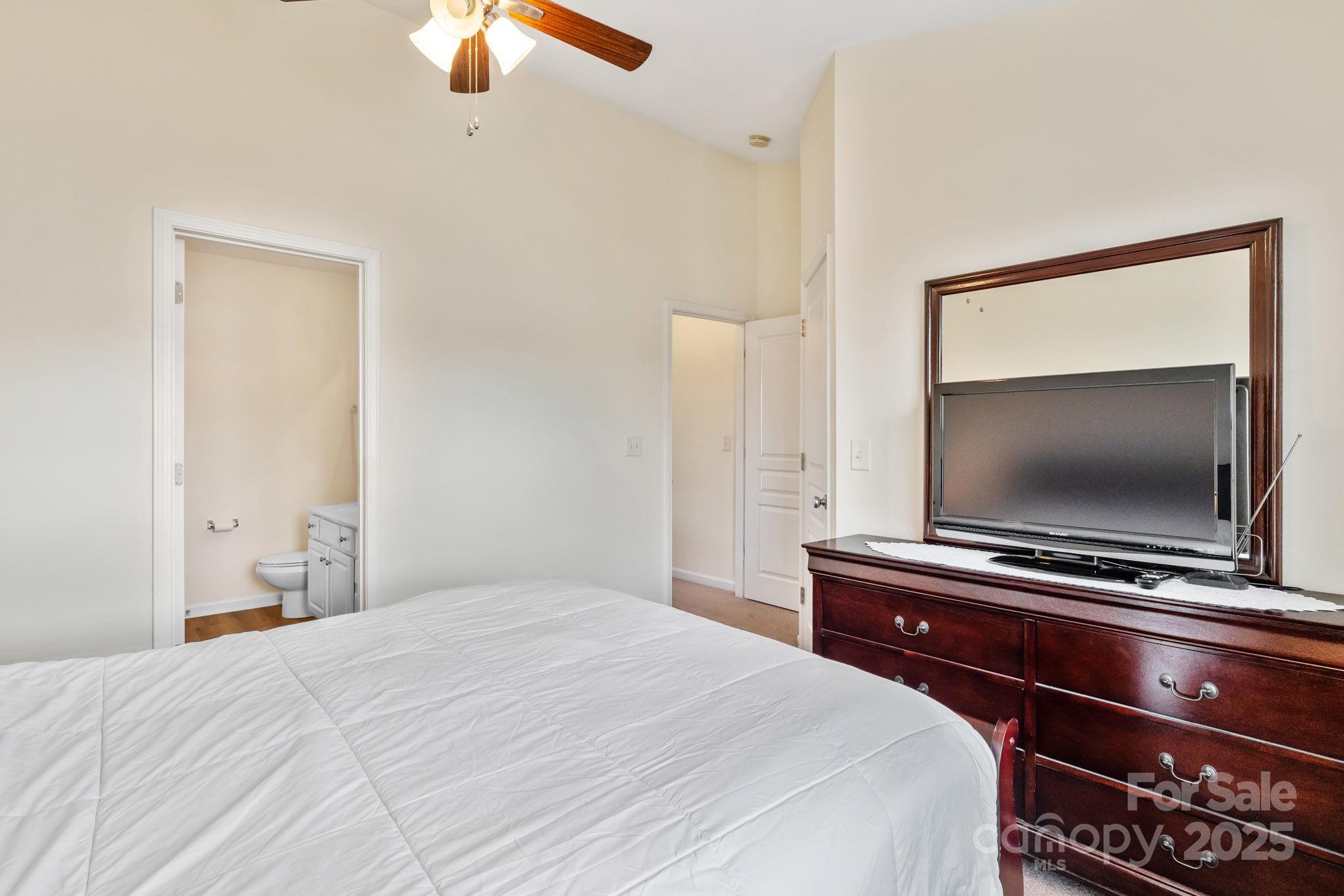 811 Gentlewinds Court Fort Mill, SC 29708 - Photo 14 of 25 a bedroom with a bed and a flat tv screen on dresser