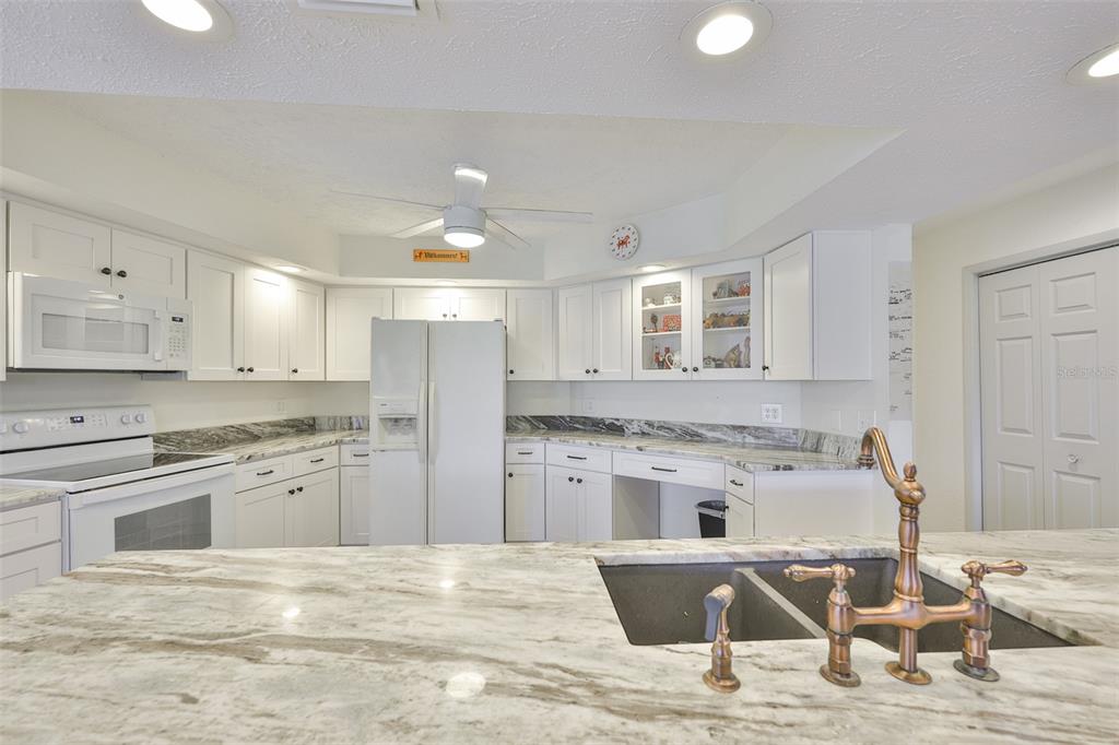 913 Allegro Lane Apollo Beach, FL 33572 - Photo 18 of 57 a kitchen with stainless steel appliances kitchen island granite countertop a kitchen island hardwood floor and a sink