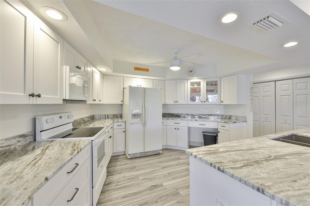 913 Allegro Lane Apollo Beach, FL 33572 - Photo 21 of 57 a kitchen with a sink dishwasher a stove and a refrigerator with wooden floor