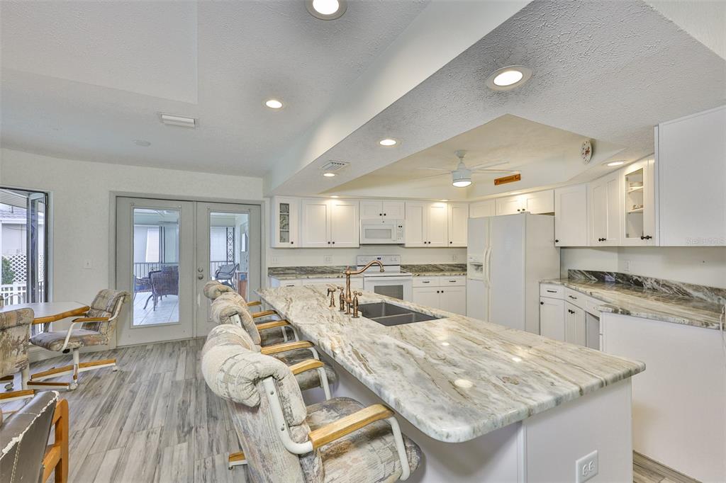 913 Allegro Lane Apollo Beach, FL 33572 - Photo 24 of 57 a kitchen with stainless steel appliances granite countertop lots of counter top space and wooden floor