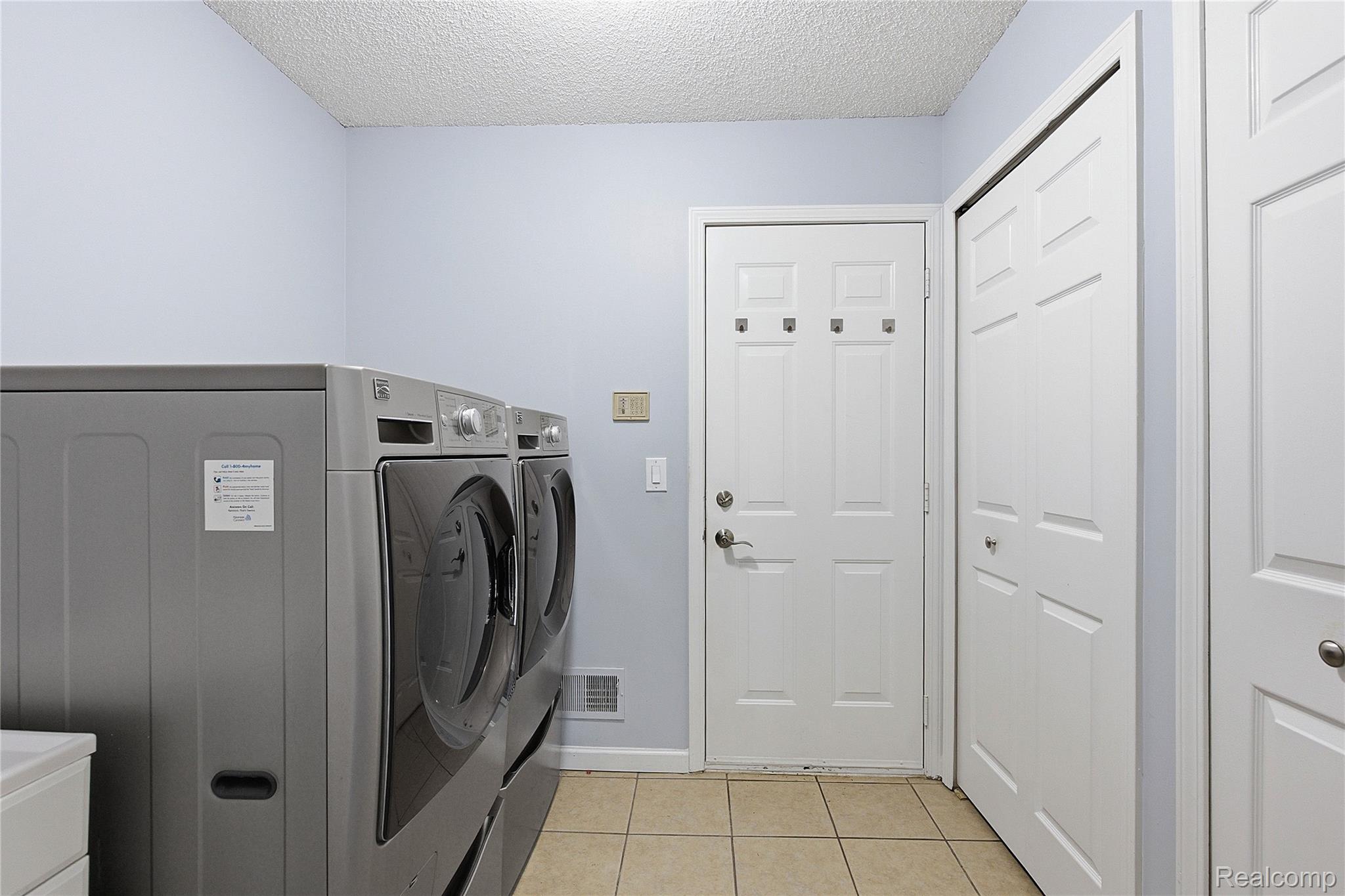 7154 Westchester Road West Bloomfield, MI 48322 - Photo 18 of 38 Laundry room with a textured ceiling, light tile patterned floors, and washing machine and clothes dryer