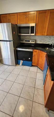 a kitchen with stainless steel appliances wooden cabinets and a stove top