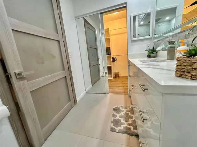 a bathroom with a granite countertop shower a sink and a mirror