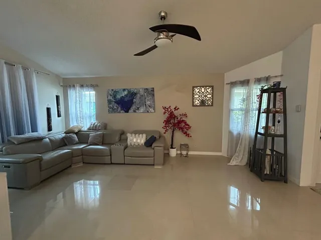 a living room with furniture and a ceiling fan