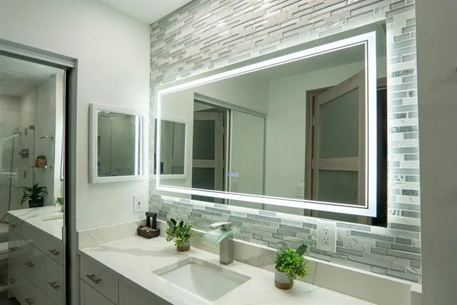 a bathroom with a granite countertop sink and a mirror