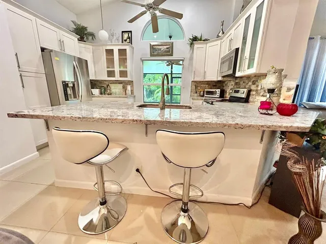 a kitchen with stainless steel appliances granite countertop a sink and a refrigerator