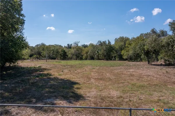 a view of a field with trees in the background