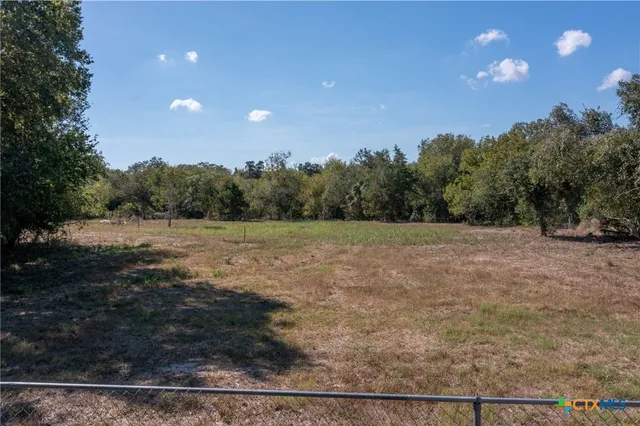 a view of a field with trees in the background