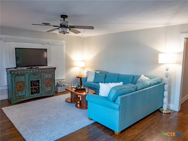 a living room with furniture a flat screen tv and a fireplace