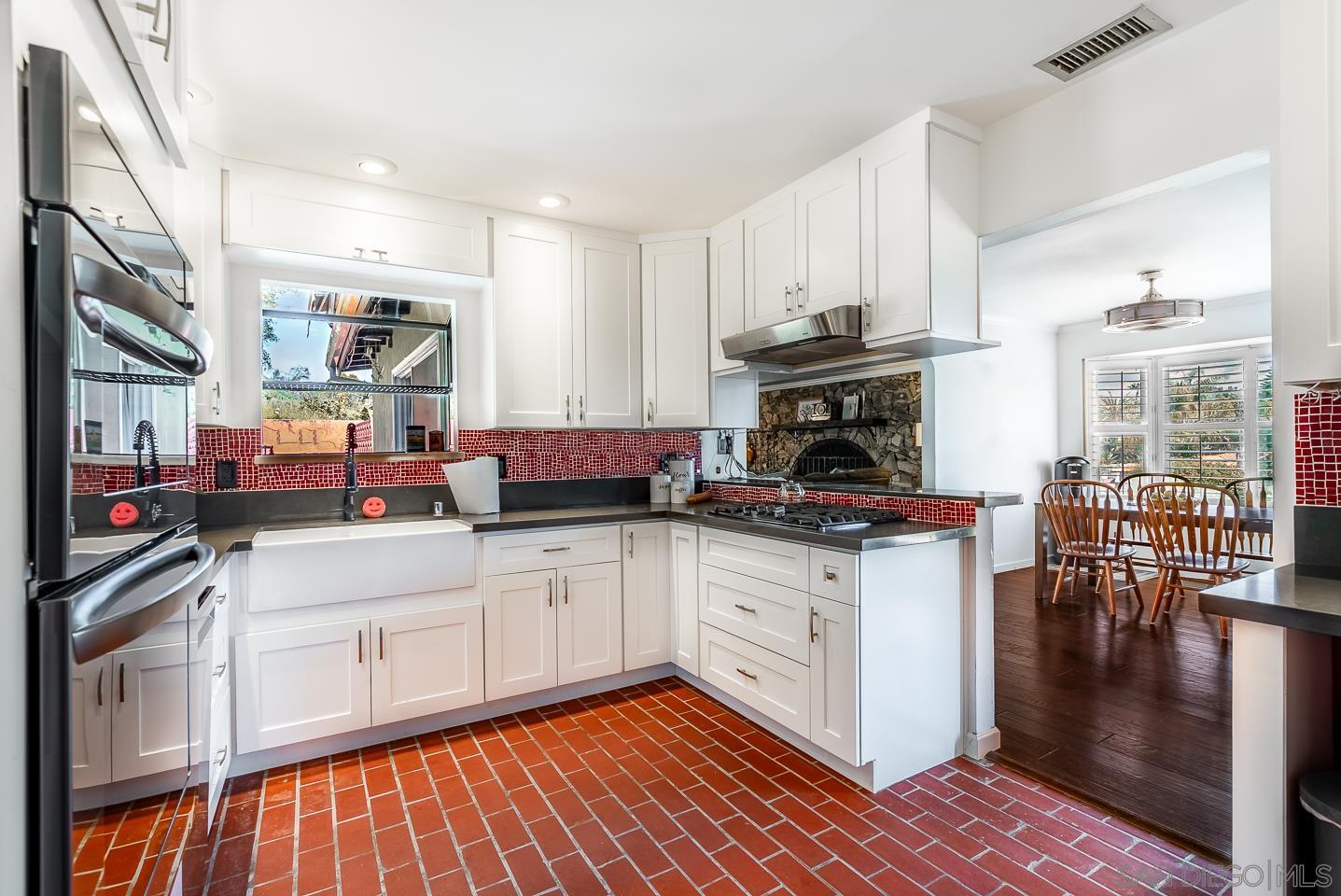 1912 Jalisco Road El Cajon, CA 92019 - Photo 3 of 38 a kitchen with stainless steel appliances granite countertop a stove top oven a sink dishwasher and white cabinets with wooden floor