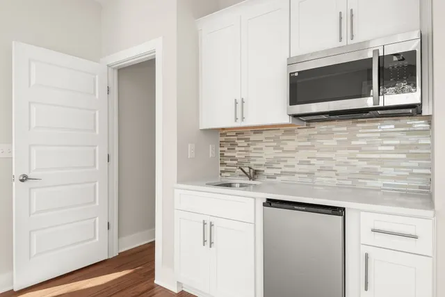 a kitchen with stainless steel appliances granite countertop a sink and a microwave