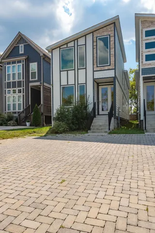 a view of a brick house with a yard and large windows