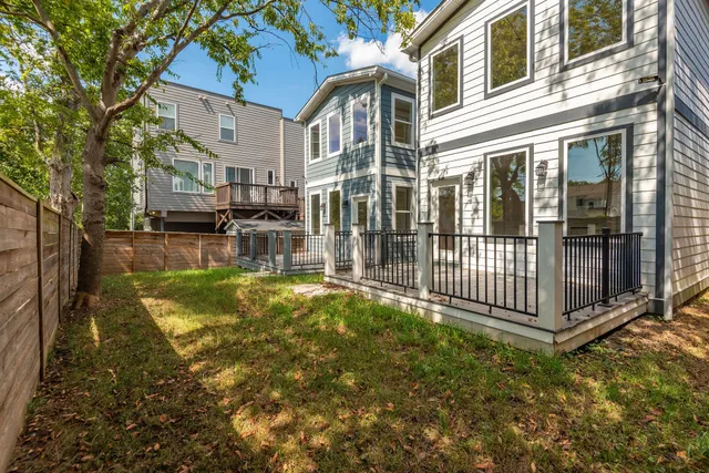 a view of a house with backyard and deck