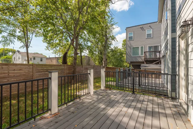 a view of a brick house with wooden floor and fence
