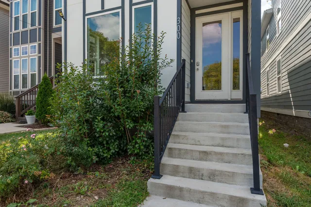 a view of a house with potted plants and a fountain