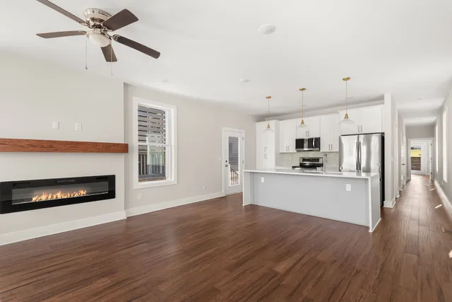 a view of kitchen with microwave a stove and wooden floor