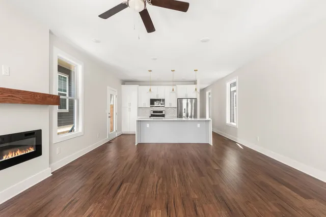 a view of empty room with wooden floor and fireplace
