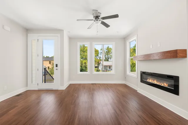 a view of wooden floor fire place and windows in a room