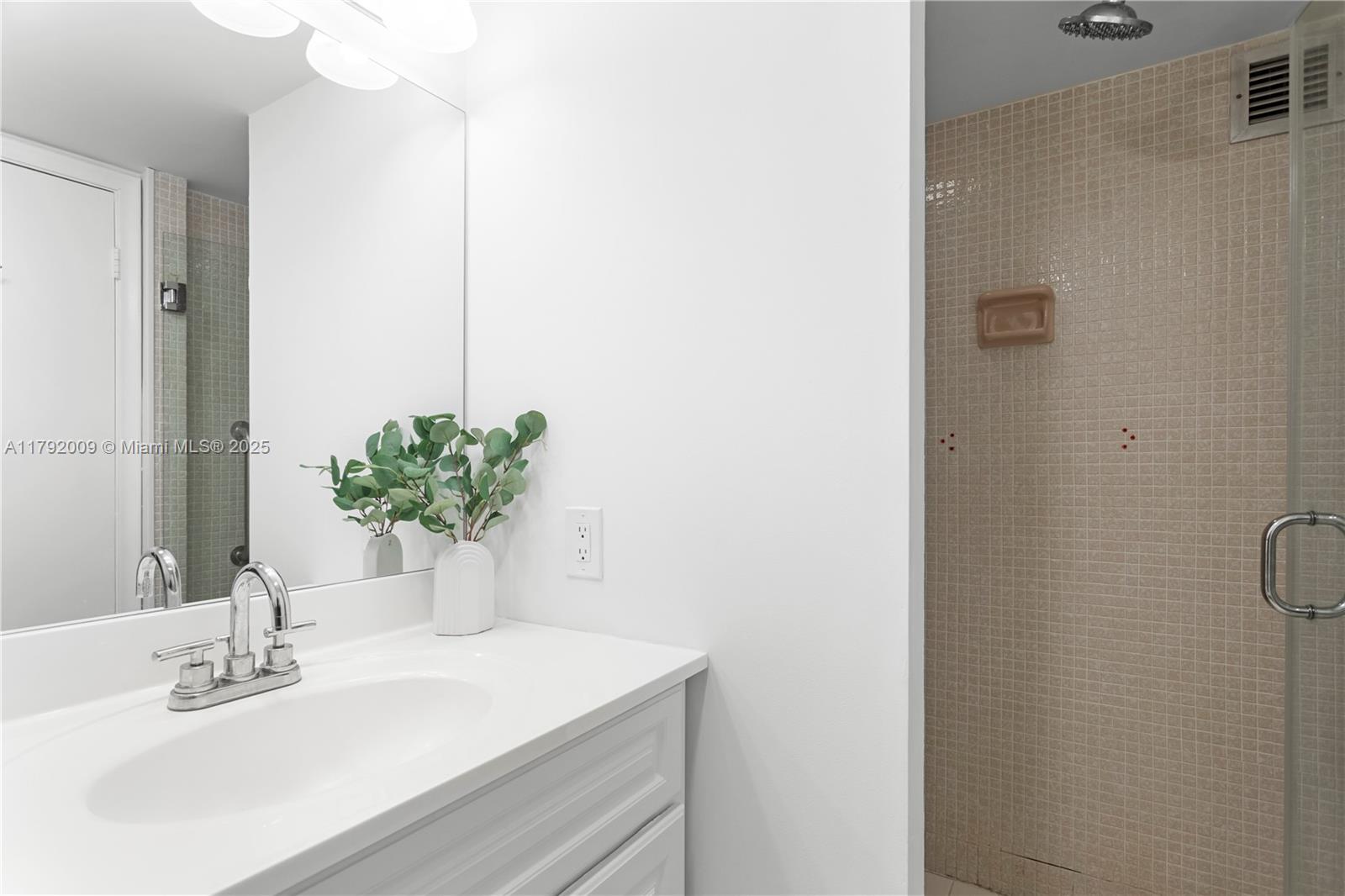 11 Island Avenue, Unit 407 Miami Beach, FL 33139 - Photo 21 of 44 a bathroom with a sink a shower and a mirror