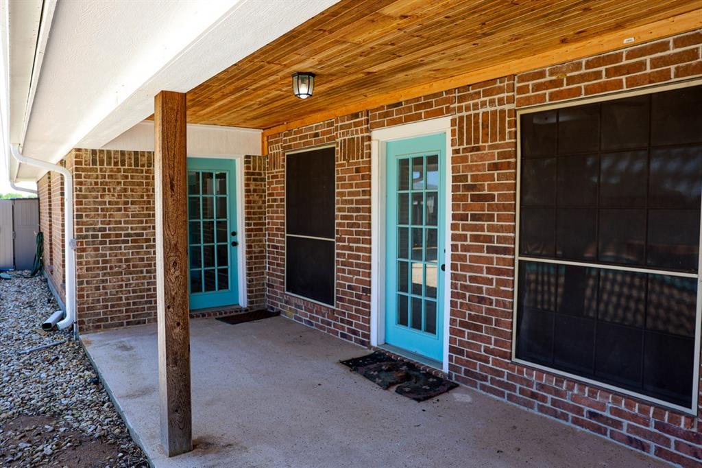 10575 Friendship Road Pilot Point, TX 76258 - Photo 27 of 32 Covered patio featuring brick exterior, a wood-finish ceiling, and concrete flooring