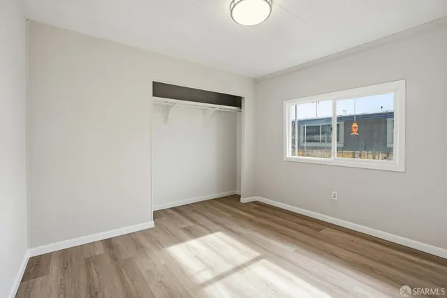 a view of a room with wooden floor and window