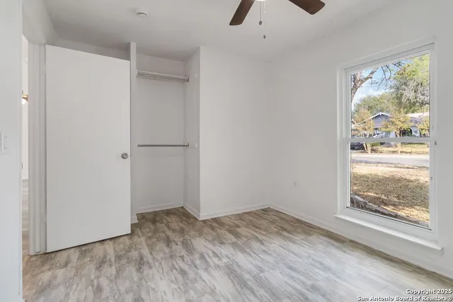 a view of empty room with wooden floor and window