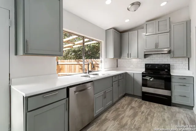 a kitchen with stainless steel appliances granite countertop a sink and a stove