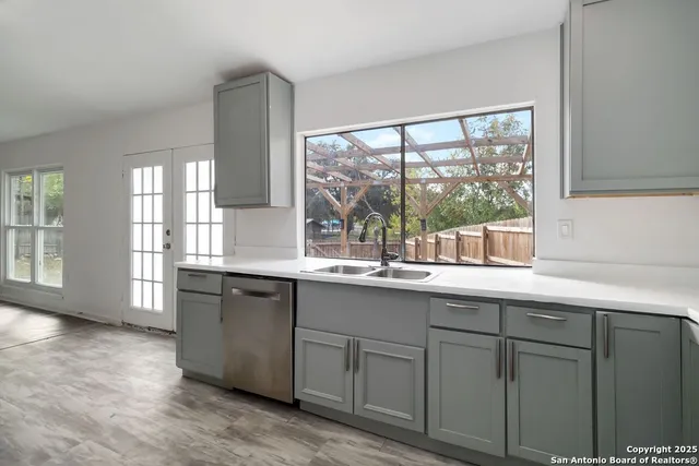 a kitchen with sink and large window