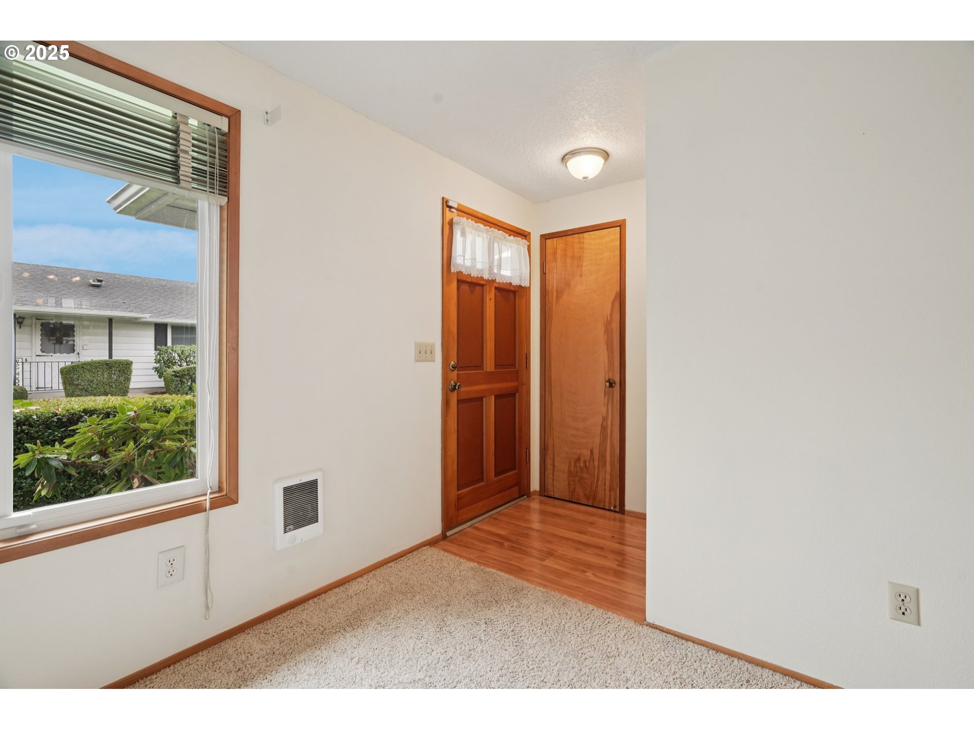 866 Northeast Fleming Avenue, Unit B83 Gresham, OR 97030 - Photo 5 of 27 a view of an empty room with wooden floor and windows