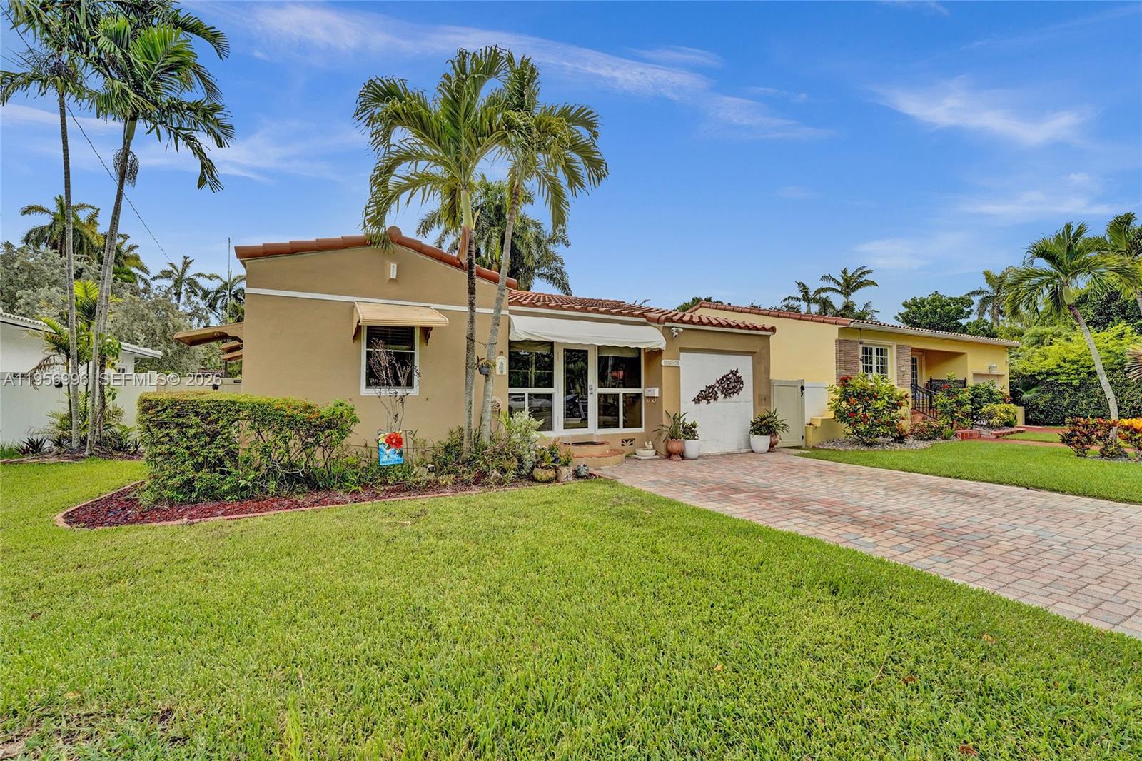 1340 Jackson Street Hollywood, FL 33019 - Photo 1 of 49 a front view of a house with a garden and yard