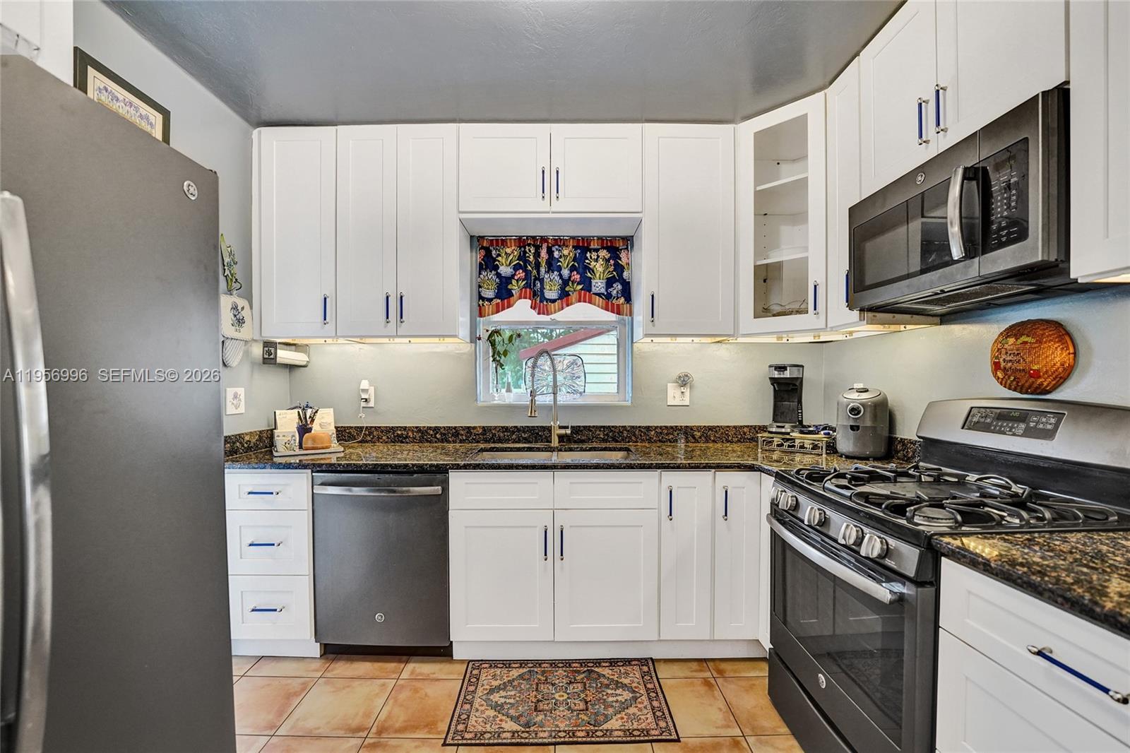 1340 Jackson Street Hollywood, FL 33019 - Photo 16 of 49 a kitchen with stainless steel appliances granite countertop a stove a sink and a microwave