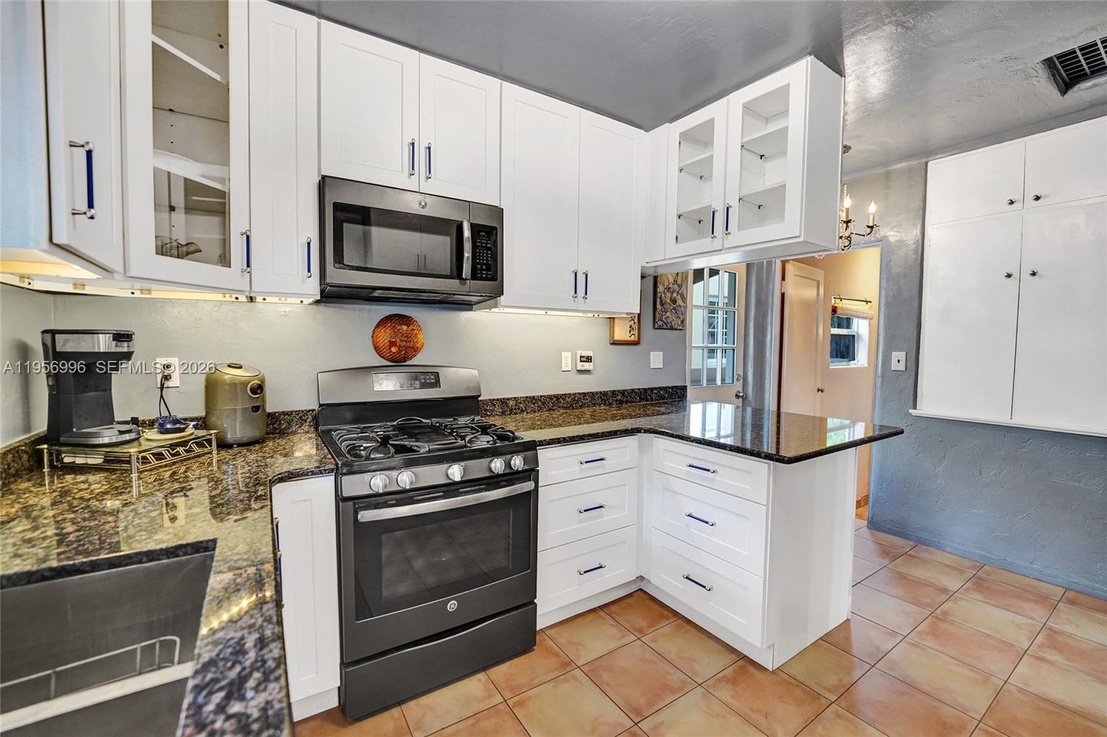 1340 Jackson Street Hollywood, FL 33019 - Photo 2 of 49 a kitchen with stainless steel appliances granite countertop a stove and a refrigerator
