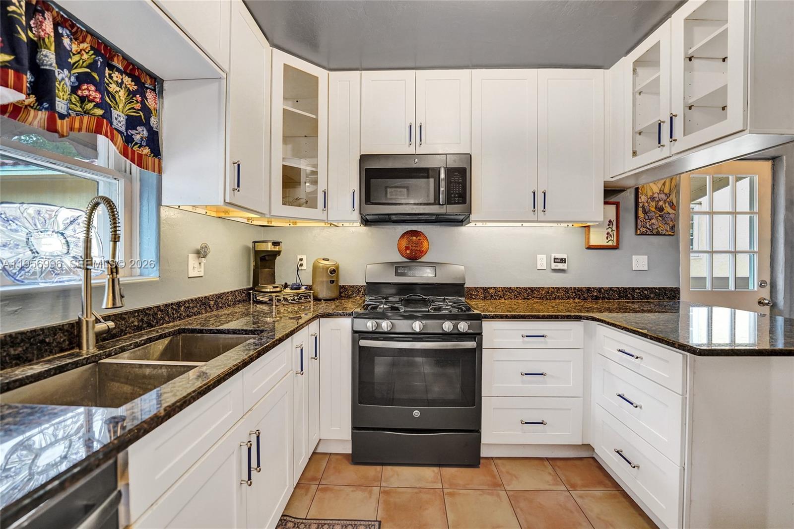 1340 Jackson Street Hollywood, FL 33019 - Photo 3 of 49 a kitchen with granite countertop a sink stainless steel appliances and cabinets
