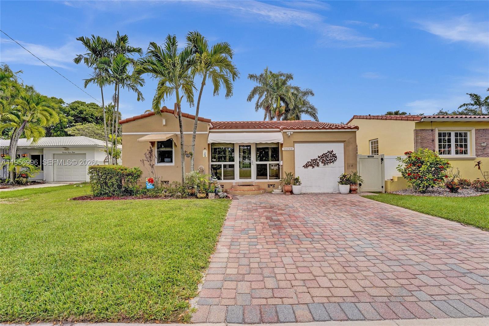 1340 Jackson Street Hollywood, FL 33019 - Photo 47 of 49 a front view of a house with a garden and yard