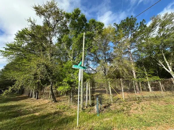 a sign board with yard in the back