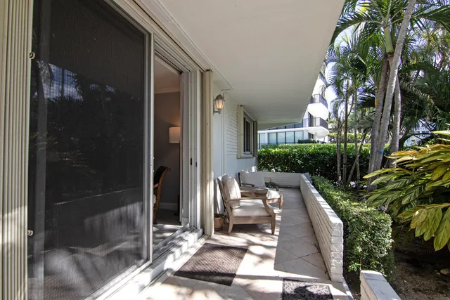 a view of balcony with two chairs and a potted plant