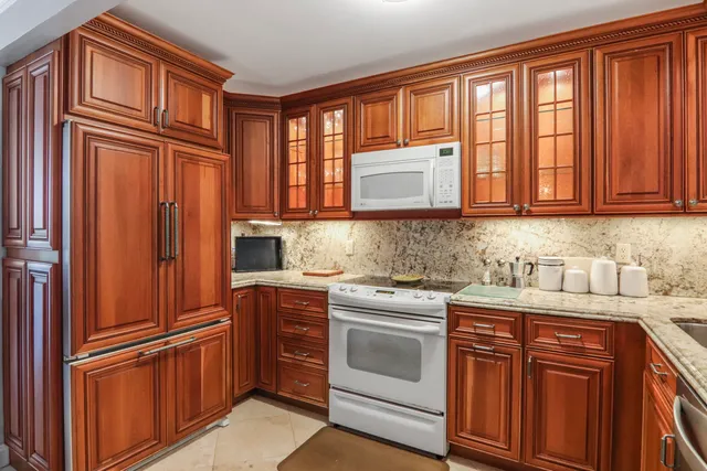 a kitchen with stainless steel appliances granite countertop a refrigerator and cabinets