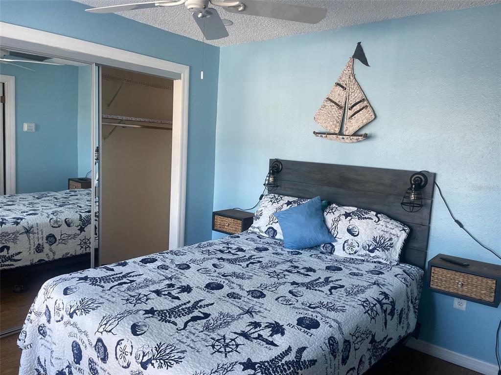 159 Medallion Boulevard, Unit E Madeira Beach, FL 33708 - Photo 11 of 15 a bedroom with a bed and a painting on the wall